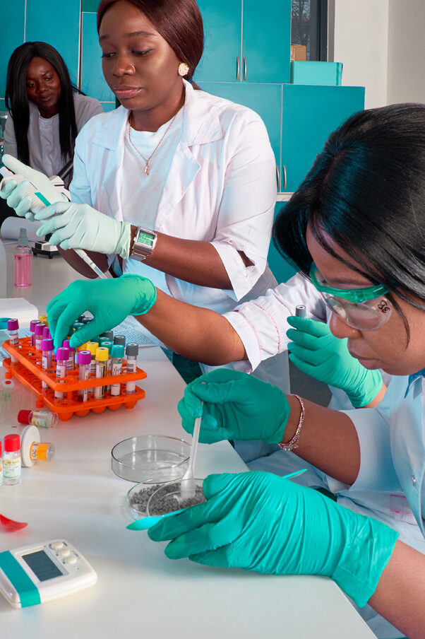 Four African women doctors in front of a laboratory bench analysing Covid-19 test samples