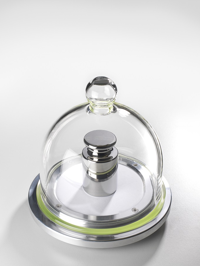 Gram weight piece under a glass bell jar.