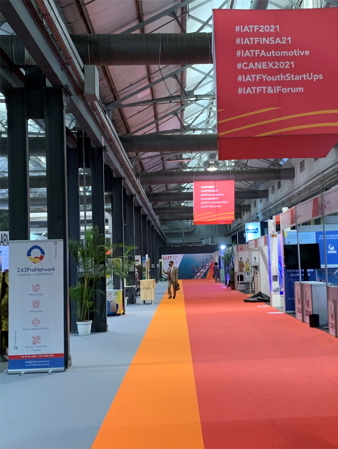In an exhibition hall of the Intra-African Trade Fair 2021, information booths are lined up on both sides. Long banners hang from the ceiling.