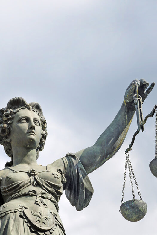A statue of the goddess Justitia holds a pair of scales.