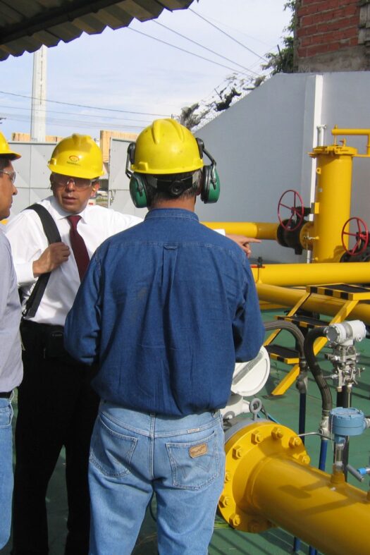 Three men wearing yellow helmets on a construction site.