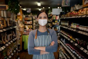 A business manager wearing a face mask while working the supermarket.