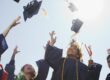 Graduates tossing caps into the air.