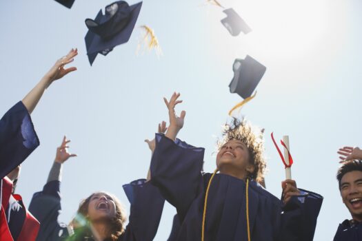 Graduates tossing caps into the air.