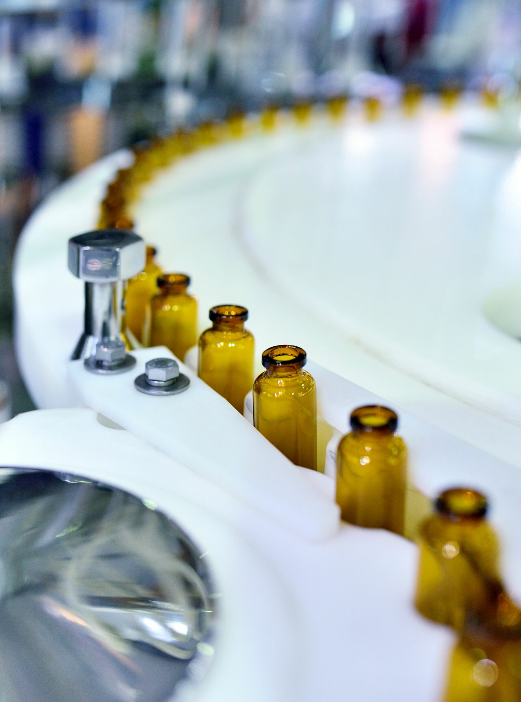 Close-up of brown glass bottles at turntable production line.