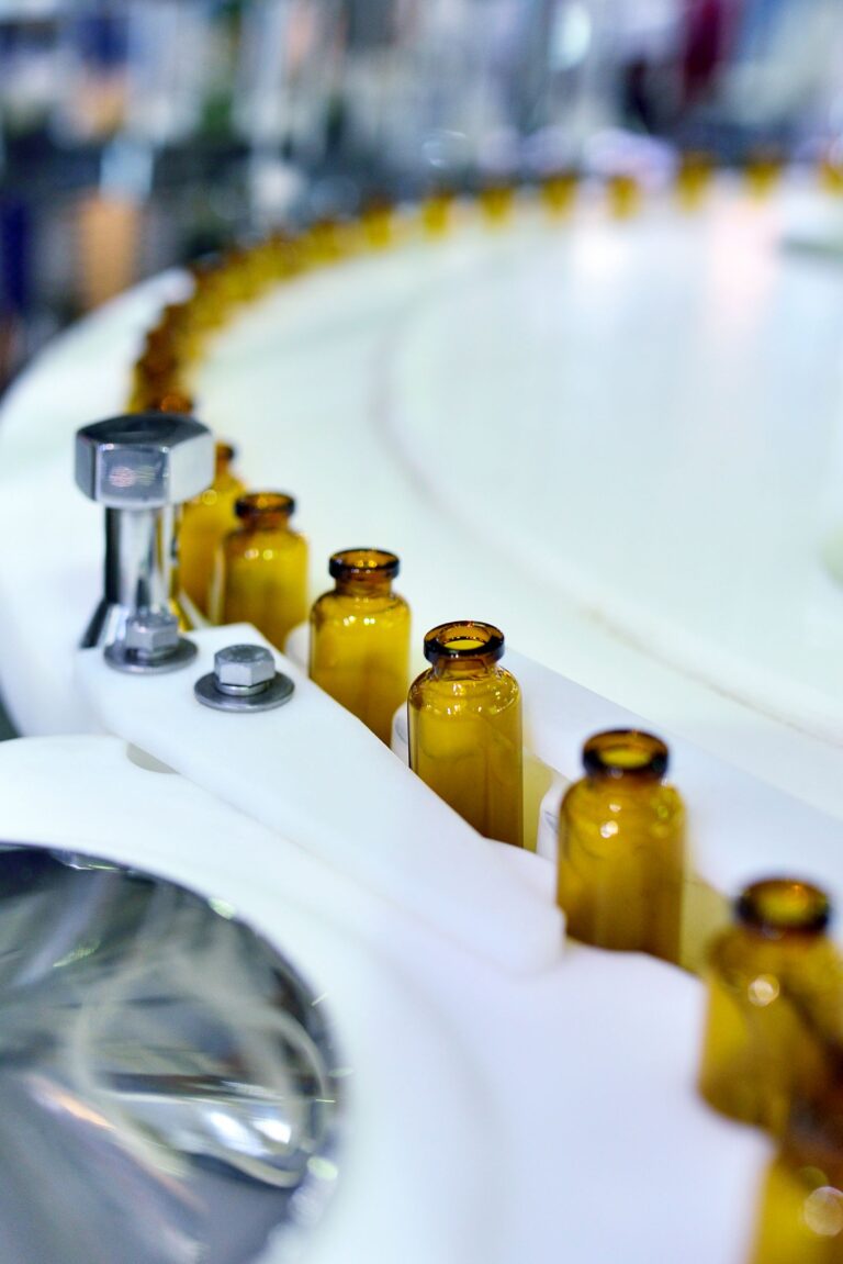Close-up of brown glass bottles at turntable production line.