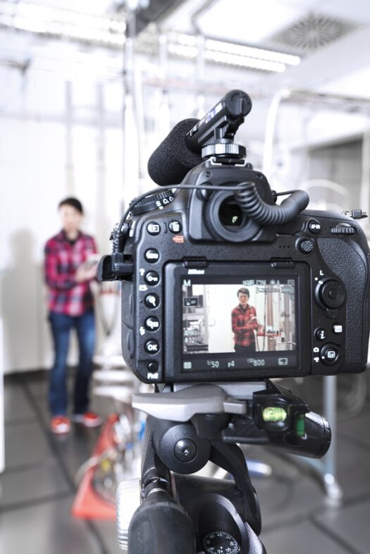 View of the display of a camera showing a woman in a laboratory.