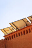 A photovoltaic system in Morocco with palm trees in the background.
