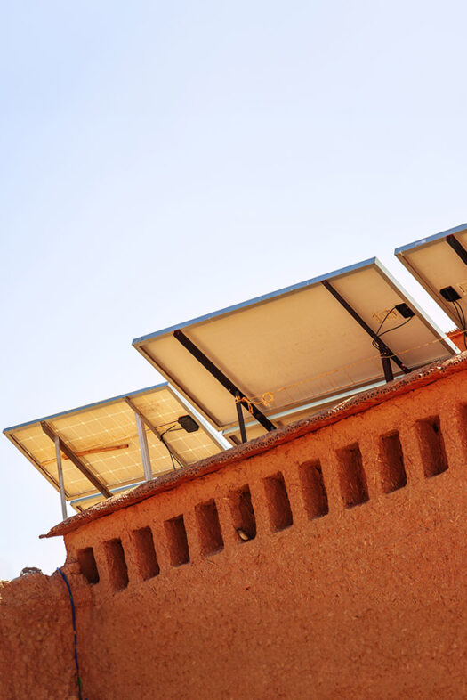 A photovoltaic system in Morocco with palm trees in the background.