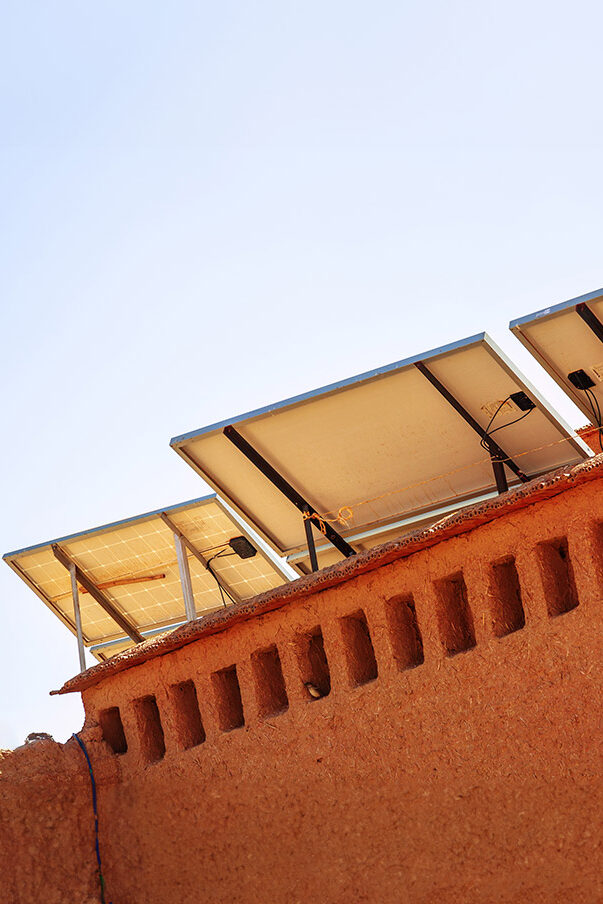 A photovoltaic system in Morocco with palm trees in the background.