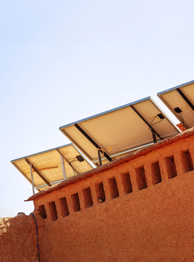 A photovoltaic system in Morocco with palm trees in the background.
