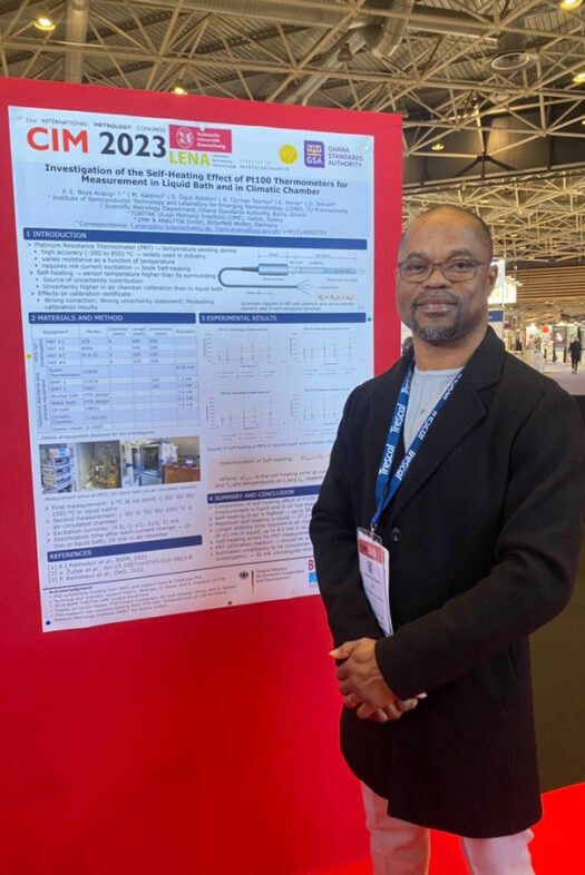 Ein Mann steht vor einem Poster, auf dem wissenschaftlicher Inhalt zu lesen ist.