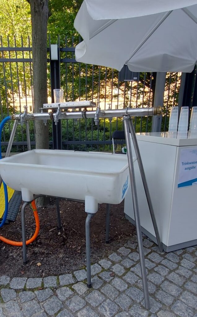 An outdoor drinking water station with six faucets