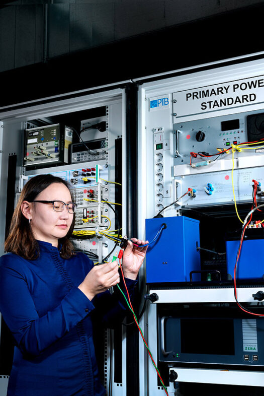 Woman in the laboratory in front of PTB's Primary Power Standard