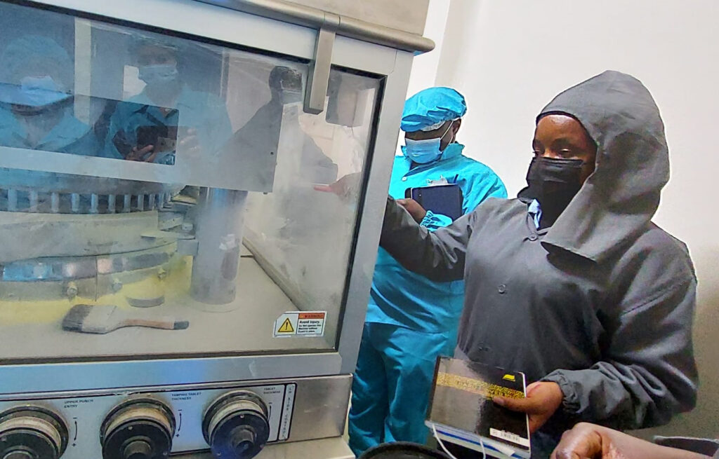 A woman and a man standing next to a machine.