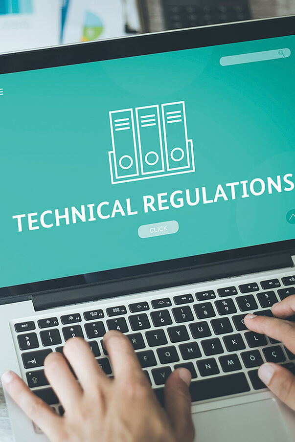 You can see hands on the keyboard of a laptop, with 'Technical Regulations' written in bold letters on the monitor.
