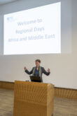A woman stands behind a podium and gives a speech.