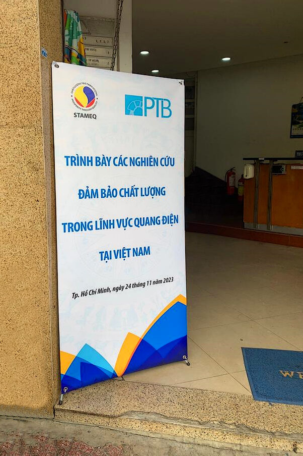 A roll-up display in a lobby with Vietnamese writing on it.