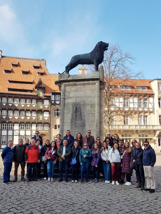 Un grupo de hombres y mujeres ante el monumento al León de Braunschweig.