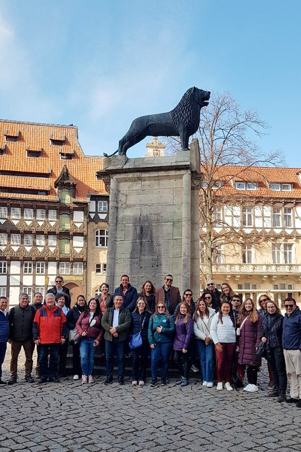 Un grupo de hombres y mujeres ante el monumento al León de Braunschweig.