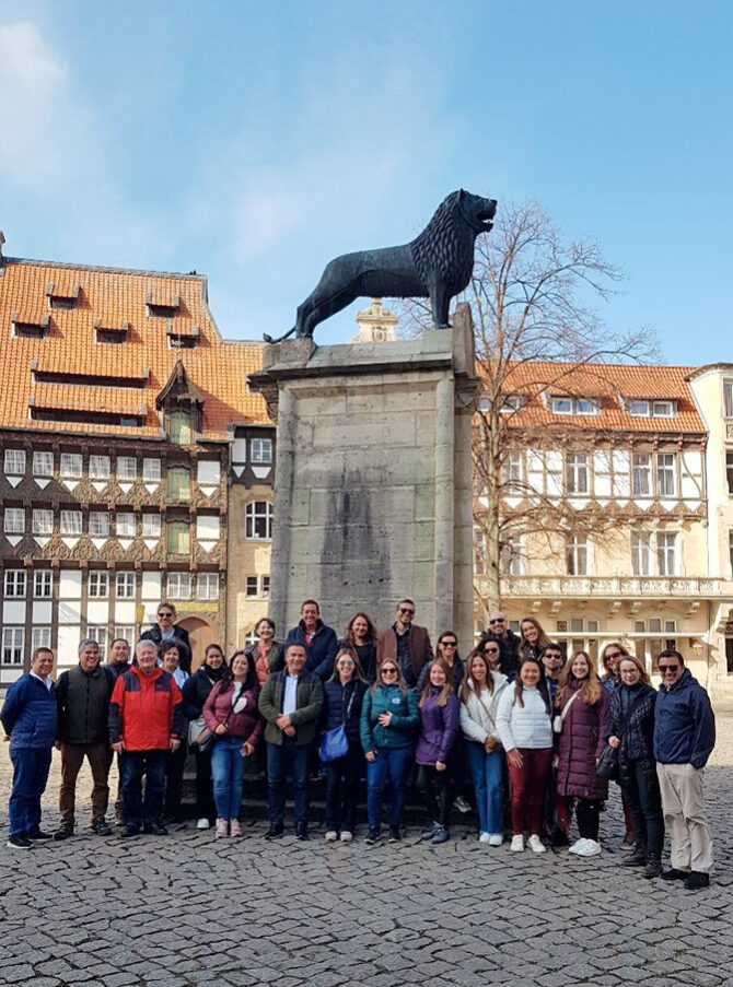 Un grupo de hombres y mujeres ante el monumento al León de Braunschweig.