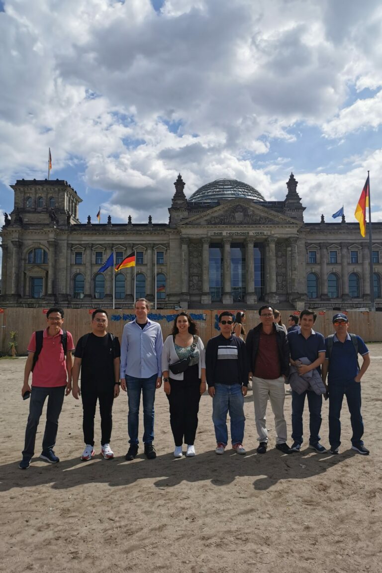 A group of people are standing in front the German Reichstag, Berlin.