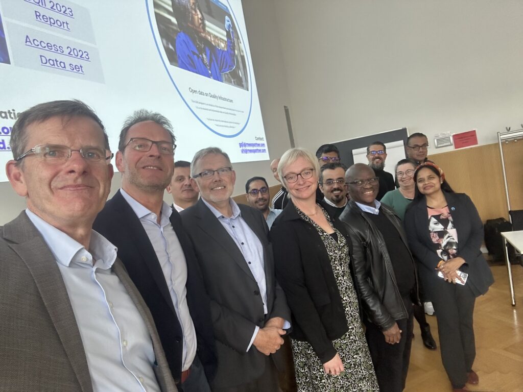 A group of 14 smiling people in front of a presentation