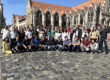 A group of people standing in front of an old Gothic building.