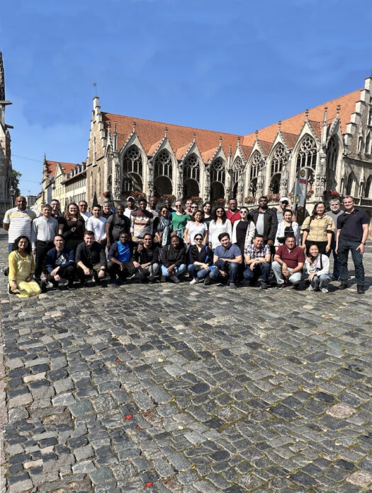 A group of people standing in front of an old Gothic building.