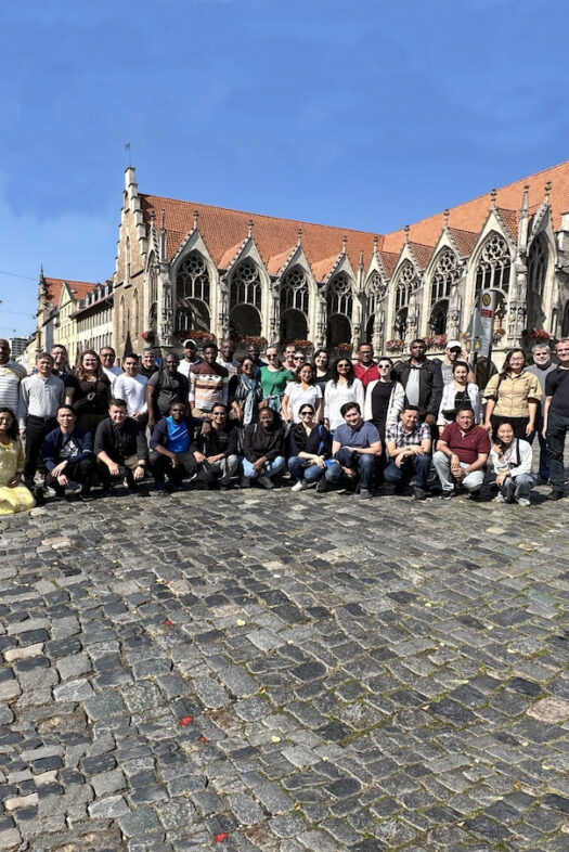 A group of people standing in front of an old Gothic building.