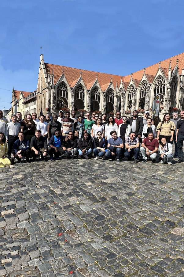 A group of people standing in front of an old Gothic building.