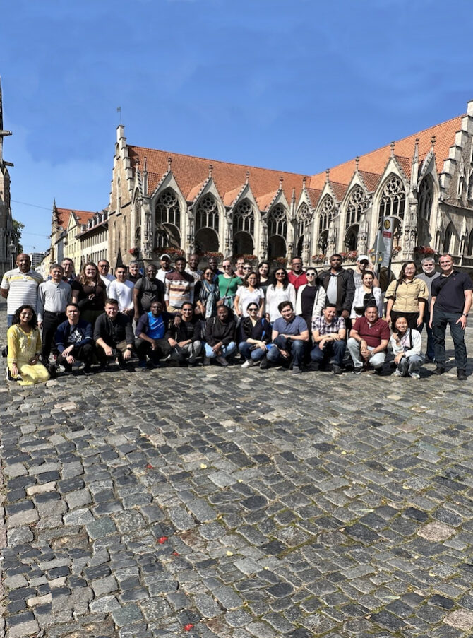 A group of people standing in front of an old Gothic building.