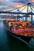 Aerial view of a container cargo ship being loaded at a commercial dock.
