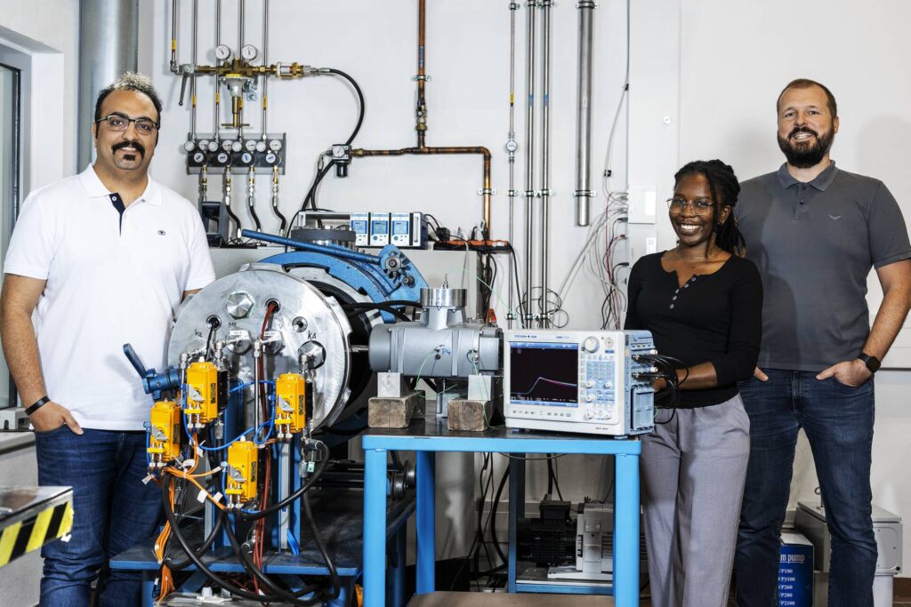 A woman and two men standing in a laboratory for explosion protection research.