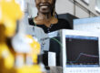 A woman standing behind research equipment for determining explosion pressure.