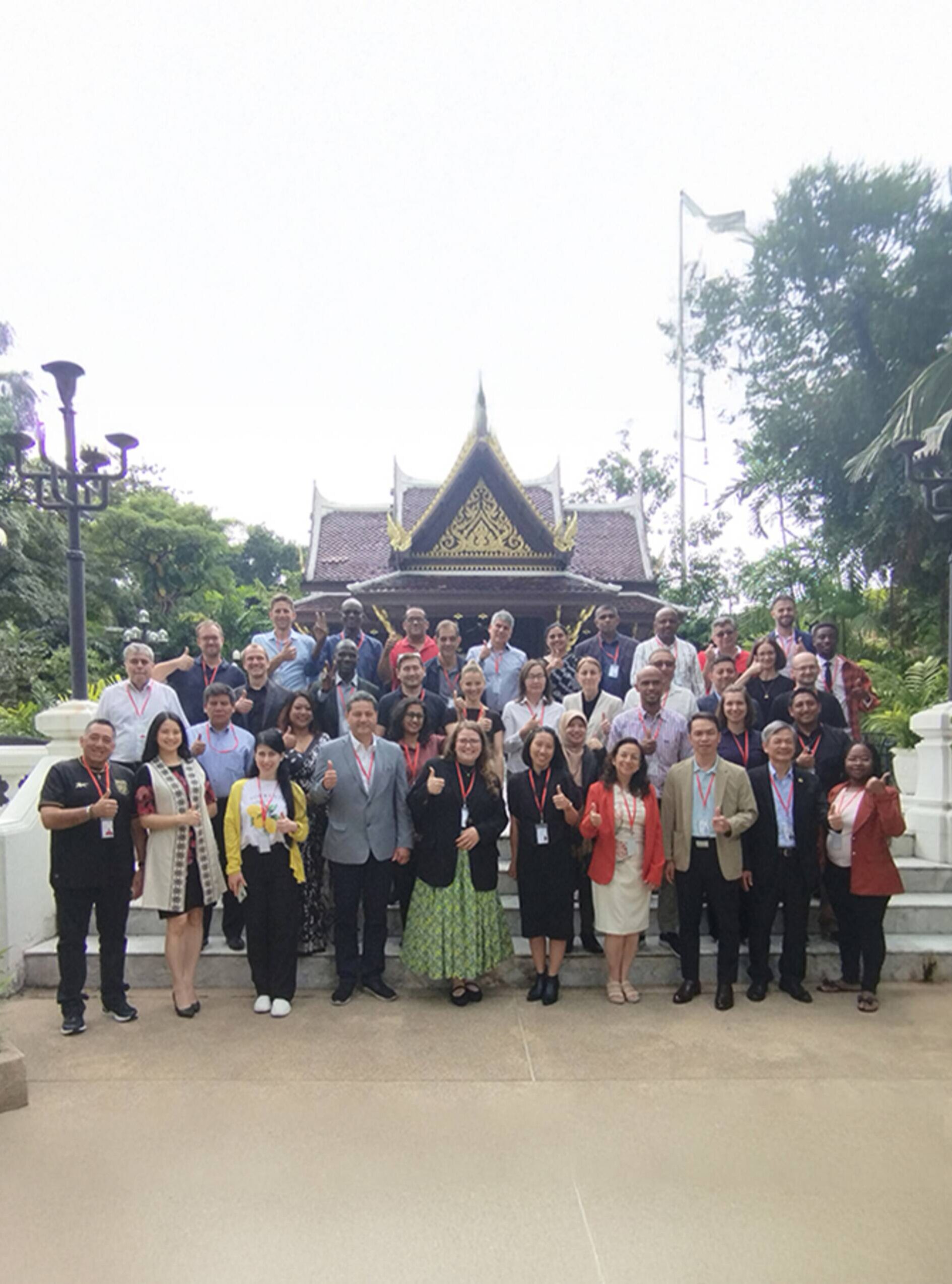 Group photo of the participants of the workshop standing outside a traditional building in Thailand
