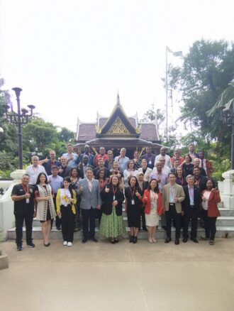 Group photo of the participants of the workshop standing outside a traditional building in Thailand