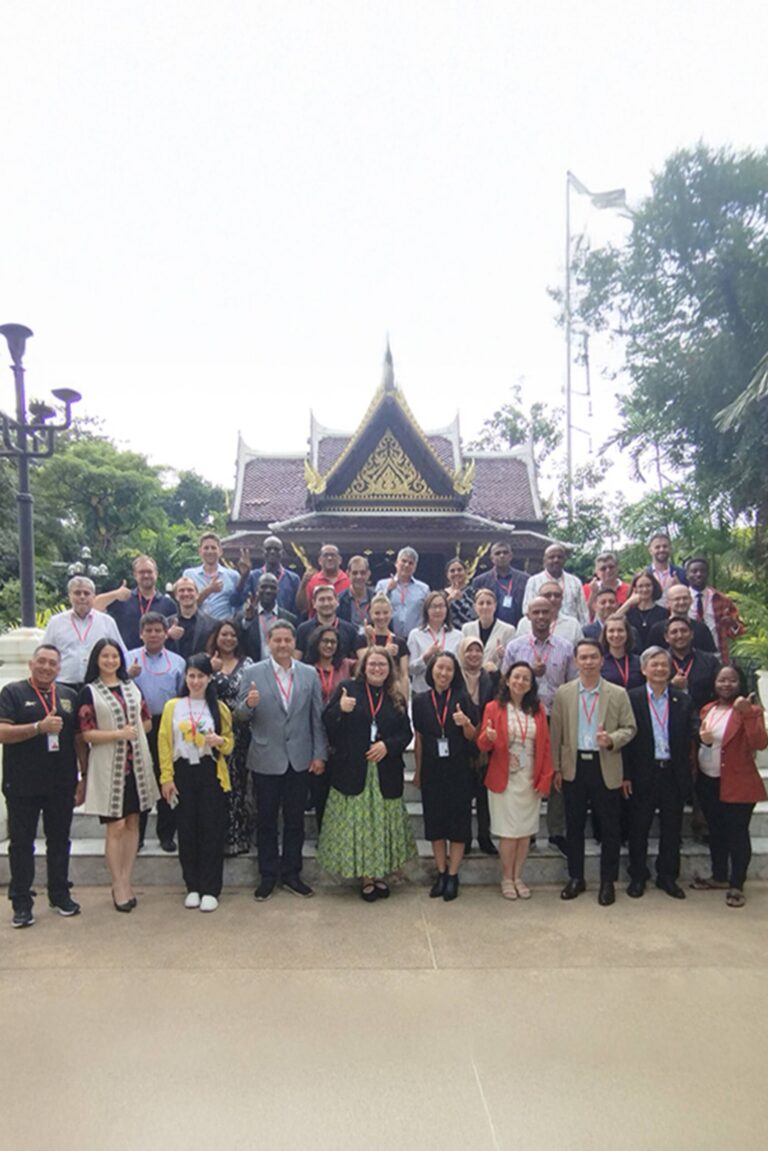 Group photo of the participants of the workshop standing outside a traditional building in Thailand