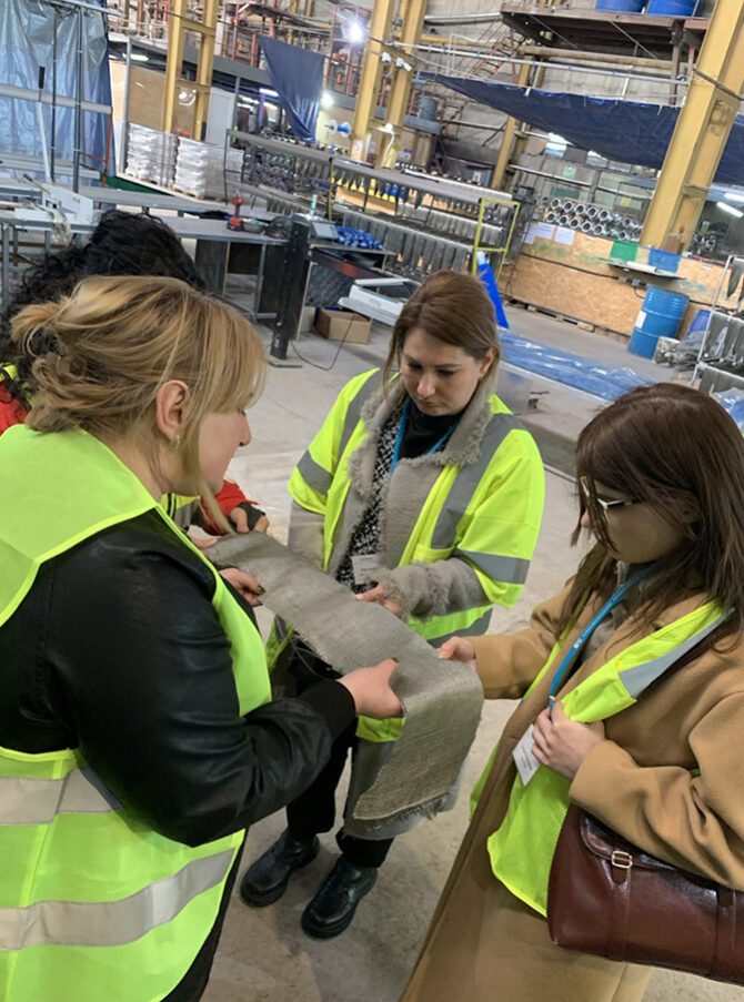 Four women are examining a swatch of fabric at Basalt Fibres Limited.